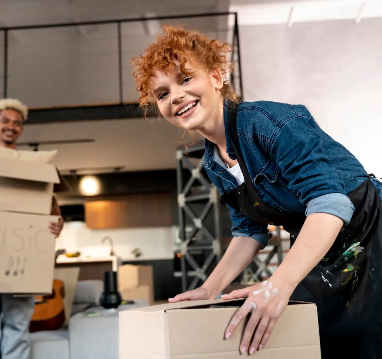 Smiling girl with curly red hair holding a box