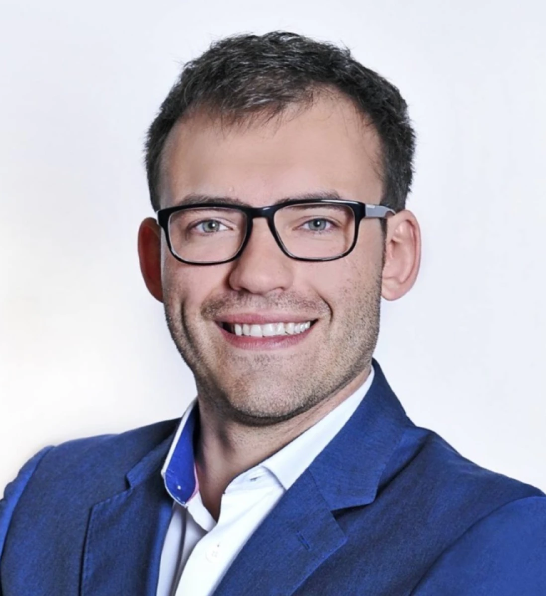 Smiling guy with glasses with black frames and blond hair